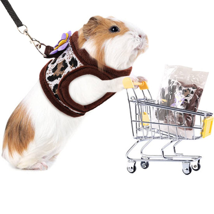 Guinea pig wearing brown leopard print harness with leash next to miniature shopping cart