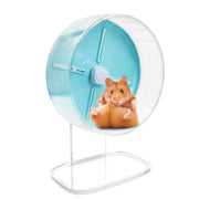 Orange hamster sitting inside clear exercise wheel with turquoise interior on white stand