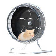 Cream colored hamster sitting inside clear exercise wheel with black interior and metal stand