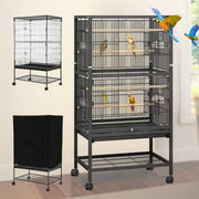 Black metal bird cage with two compartments, perches, and colorful parrots inside on wheels