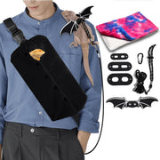 Person wearing black lizard carrier bag across chest with bearded dragon inside and bat wings leash