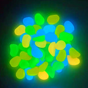 Glowing aquarium rocks in blue, green and yellow colors creating luminous bokeh effect