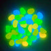 Glowing aquarium rocks in blue, green and yellow colors creating luminous bokeh effect
