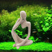 Artistic sandstone thinker statue in meditation pose surrounded by lush green aquarium plants