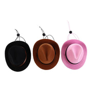 Three mini cowboy hats in black brown and pink with chin strap cords arranged side by side