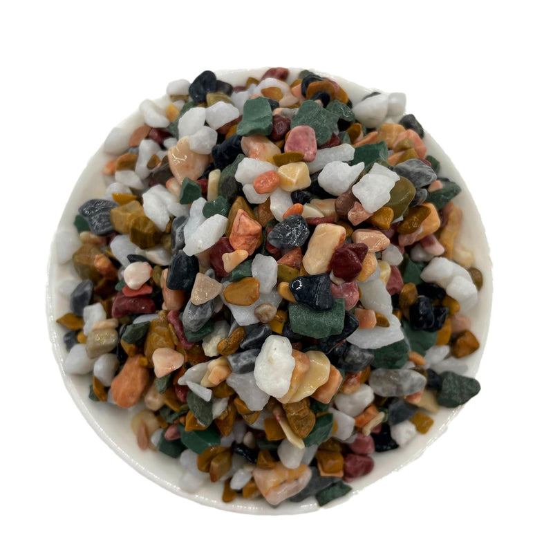 Colorful mixed aquarium gravel stones in white bowl showing variety of natural rock colors
