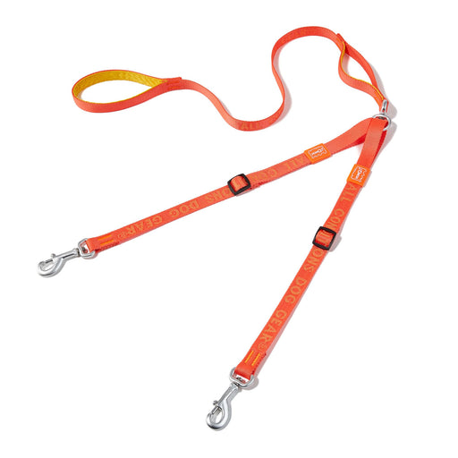 Orange dual dog leash with metal clips and adjustable straps laid out on white background
