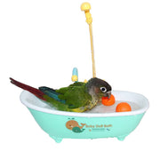 Green parrot with red tail feathers bathing in turquoise toy bathtub with shower attachment
