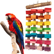 Colorful wooden block parrot toy hanging next to red and blue macaw on natural branch