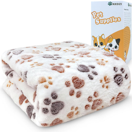 White coral velvet dog blanket with brown and gray paw print pattern next to product box
