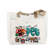 Cream canvas tote bag with colorful pet groomer sublimation design featuring scissors and paw prints