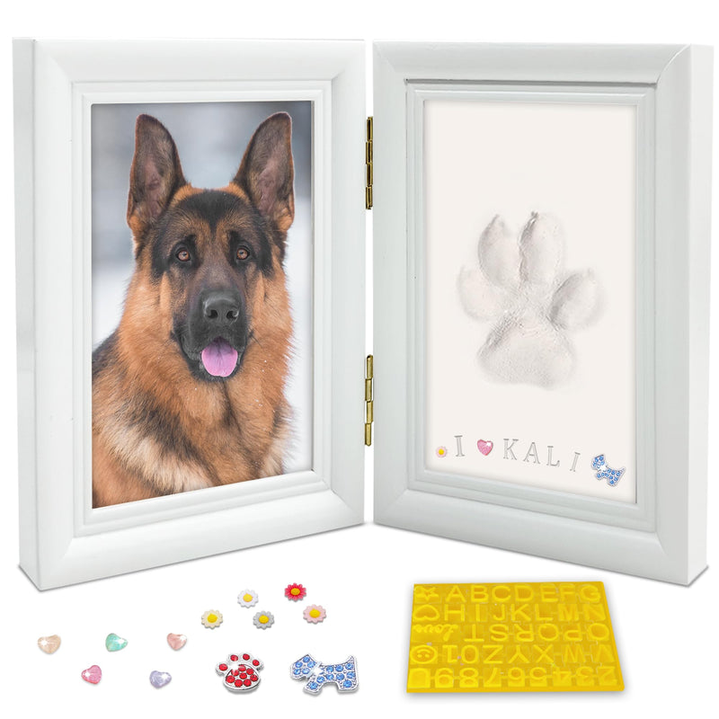White double frame with German Shepherd photo and clay paw print beside letter stamps and gem