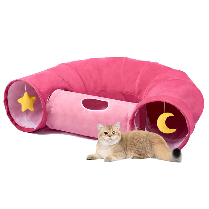 Pink collapsible cat tunnel with star and moon decorations, golden British Shorthair cat lying