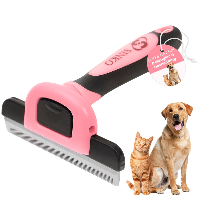 Pink and black pet deshedding brush with metal comb blade next to orange cat and golden dog