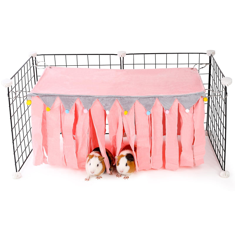 Pink guinea pig hideout with fabric strips attached to wire cage, two guinea pigs underneath
