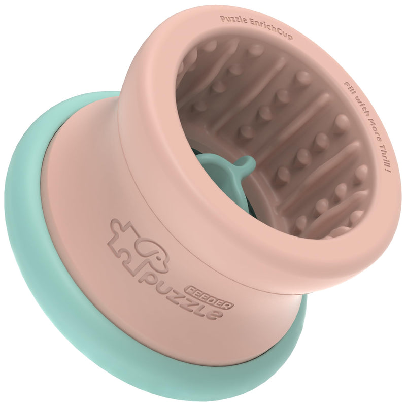 Pink and mint green interactive puzzle dog feeder bowl with textured interior and puzzle pieces