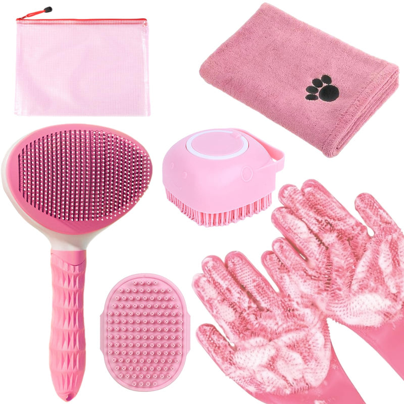 Pink pet grooming tools laid out including brushes, towel, gloves and storage bag