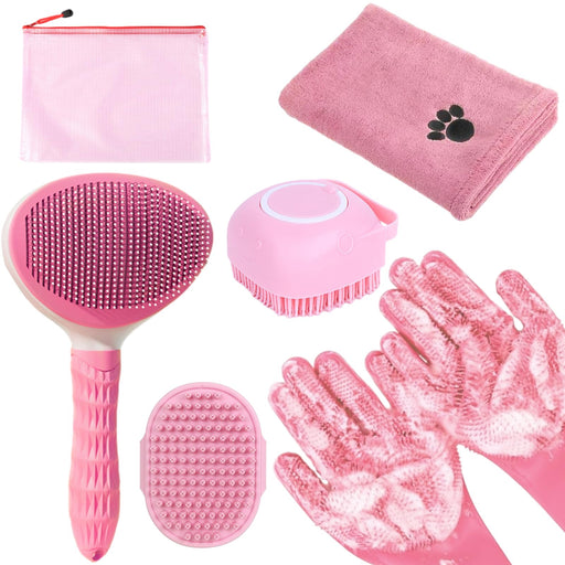 Pink pet grooming tools laid out including brushes, towel, gloves and storage bag