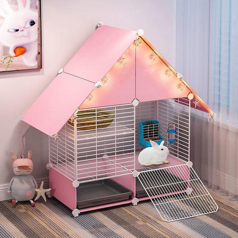 Pink triangular rabbit cage with tent-like cover, fairy lights, white bunny inside, and toys nearby