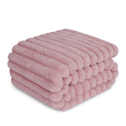 Pink ribbed waterproof dog blanket stacked in multiple layers showing plush textured surface