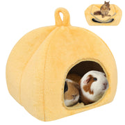 Yellow pumpkin-shaped pet hideout with guinea pigs inside and squirrel on top shown in use