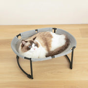 Ragdoll cat with blue eyes resting in a grey mesh elevated pet hammock bed