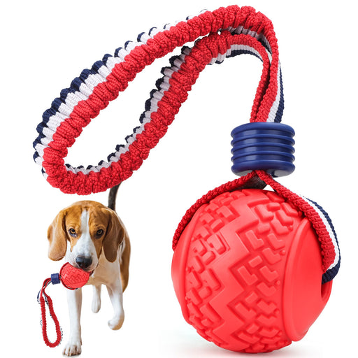 Red textured rope ball dog toy with blue handle grip and beagle holding it in mouth