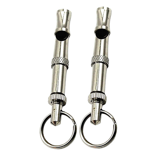 Two silver metal dog training whistles with keyrings on white background