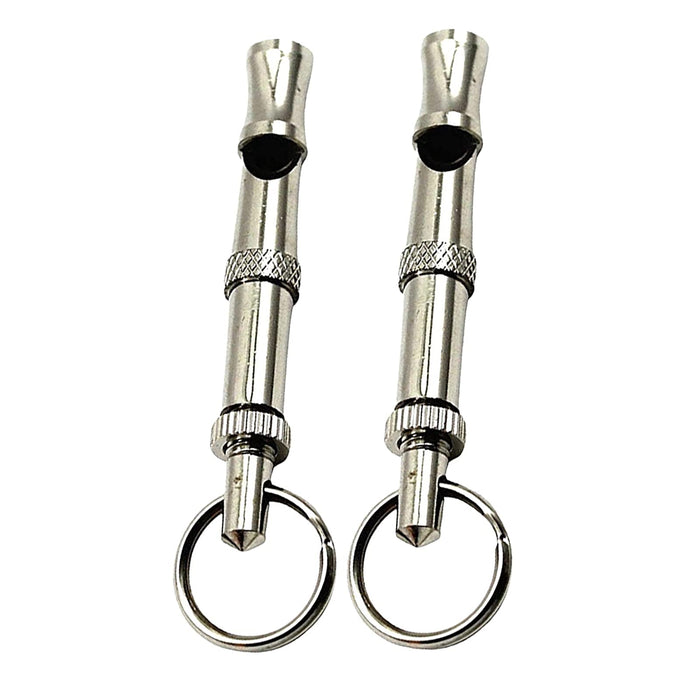Two silver metal dog training whistles with keyrings on white background