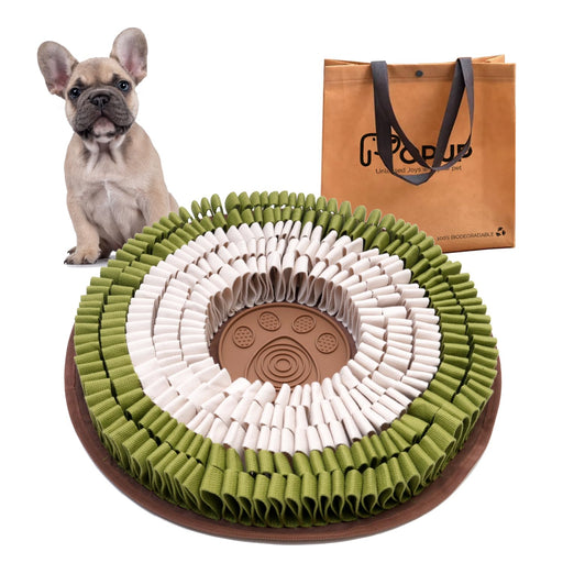 Green and white snuffle mat with brown center alongside French bulldog and orange shopping bag