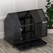 Black steel dog kennel with house-shaped roof and ventilation holes on wooden floor