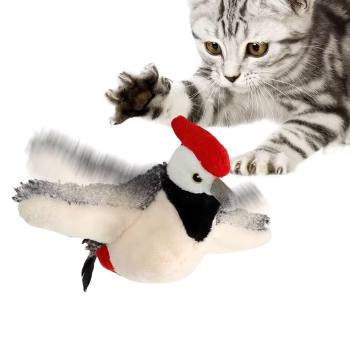 Silver tabby cat with golden eyes playing with white and gray bird toy with red beret