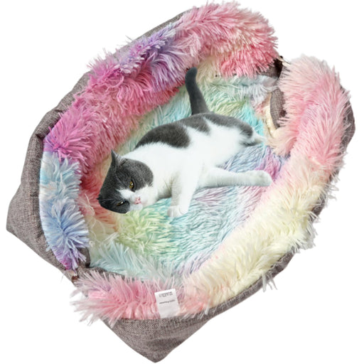 Gray and white cat lying in colorful tie-dye faux fur pet bed with pink, blue, and green fur