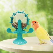 Colorful lovebird next to turquoise rotating foraging feeder with seeds on white surface