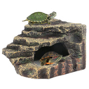 Natural rock reptile basking platform with two turtles, one on top and one inside cave opening