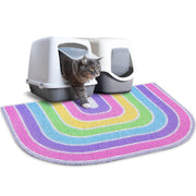 Gray tabby cat exiting white hooded litter box on colorful rainbow striped trapping mat
