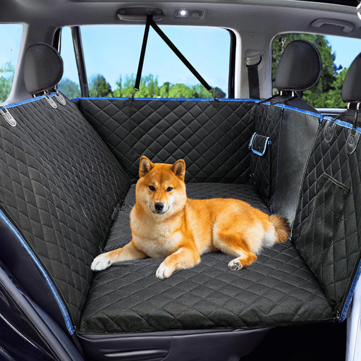 Shiba Inu dog lying on black quilted waterproof car seat hammock cover in vehicle backseat