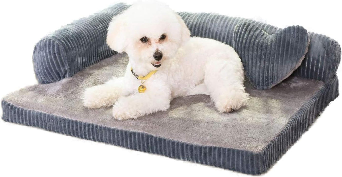 White Bichon Frise dog lying on gray corduroy L-shaped orthopedic bed with raised sides