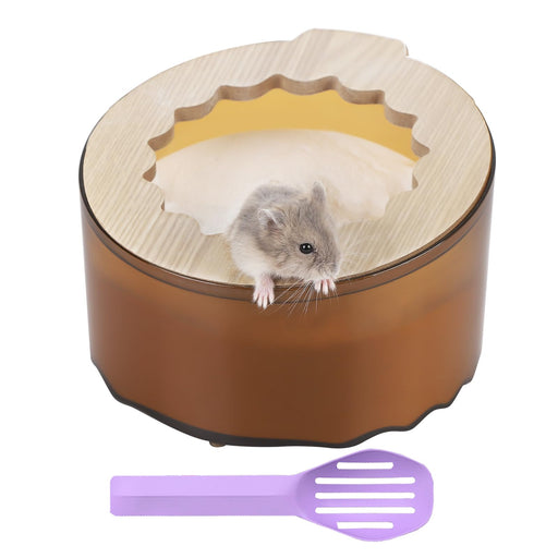 Gray hamster peeking out of round wooden sand bath container with purple cleaning spoon below