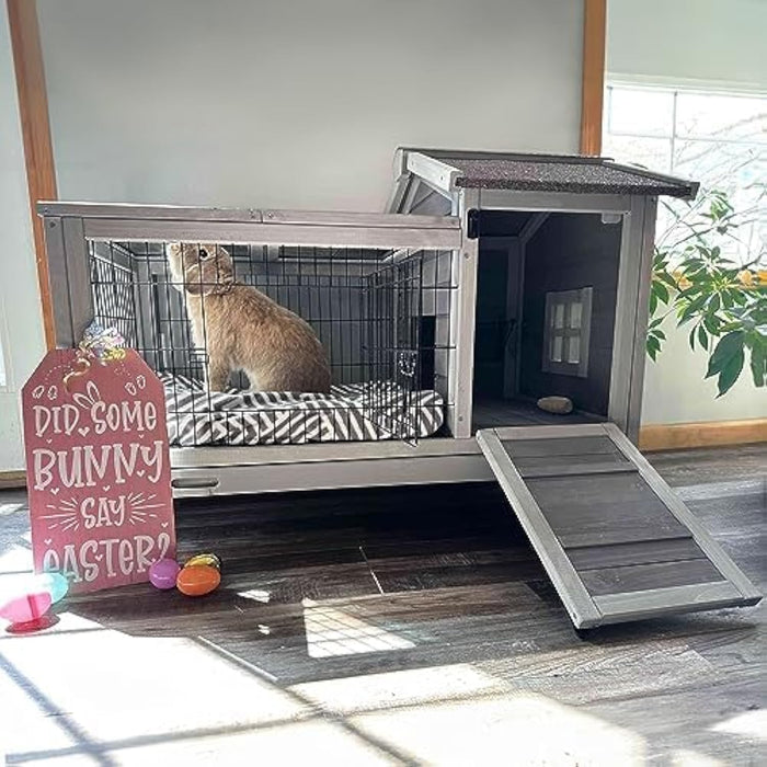 Large wooden rabbit hutch with wire enclosure, dark shelter area, ramp, and Easter sign nearby